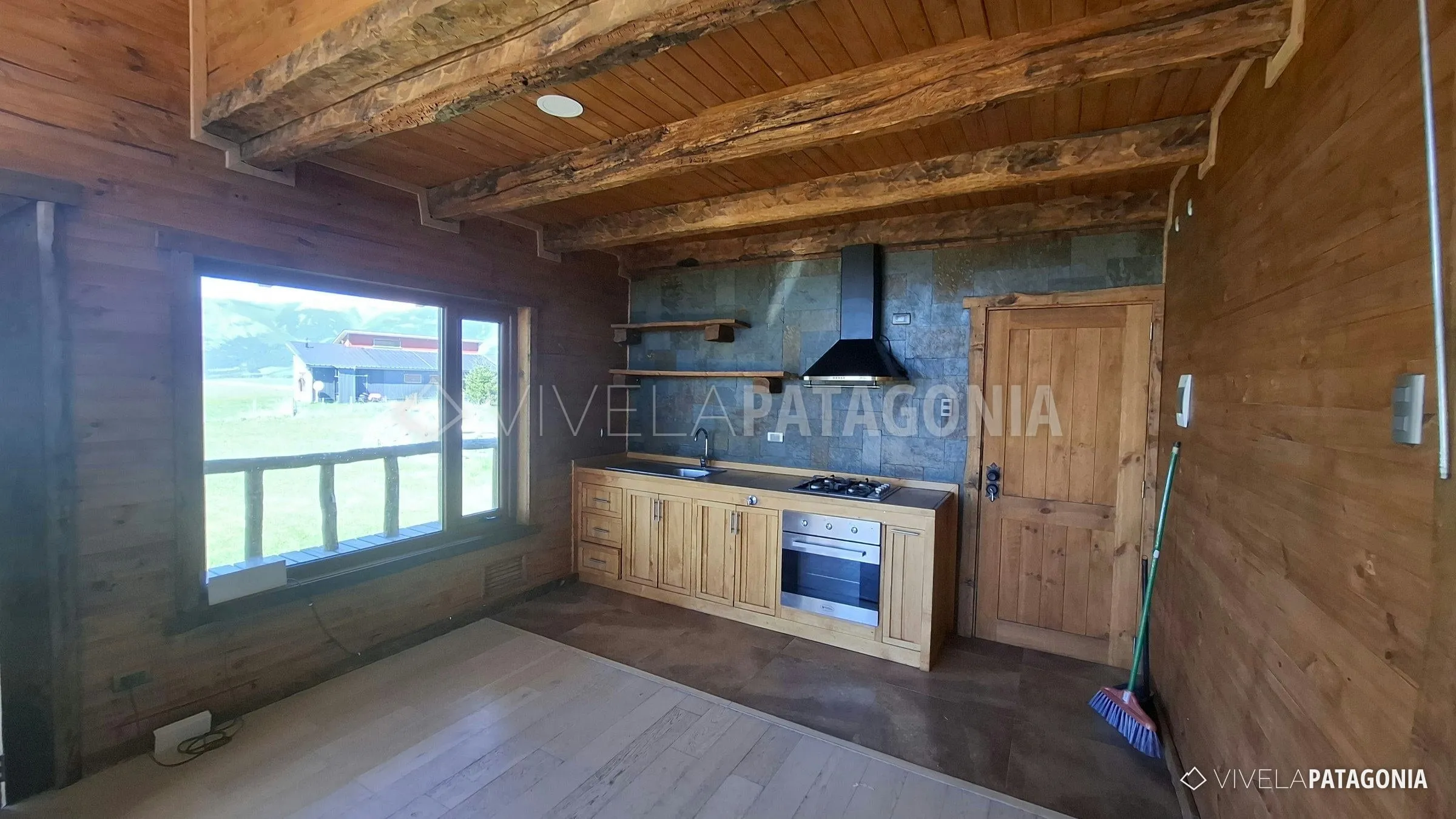 Cocina con horno eléctrico, encimera y muebles de madera · Casa en parcela en arriendo · Panguilemu